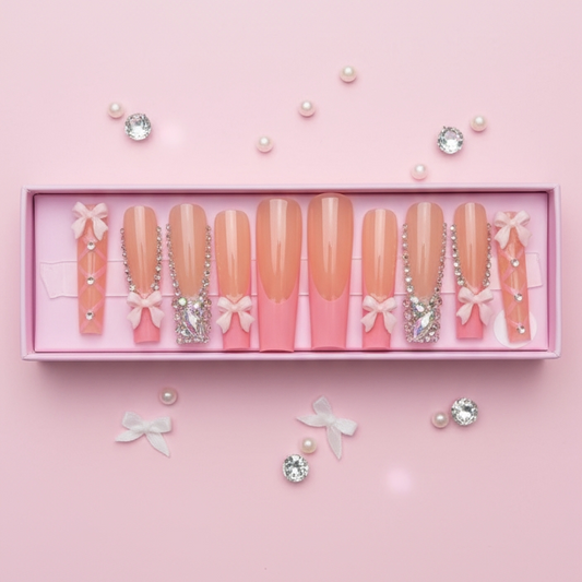 Set of press-on nails with decorative elements in a pink box on a pink background
