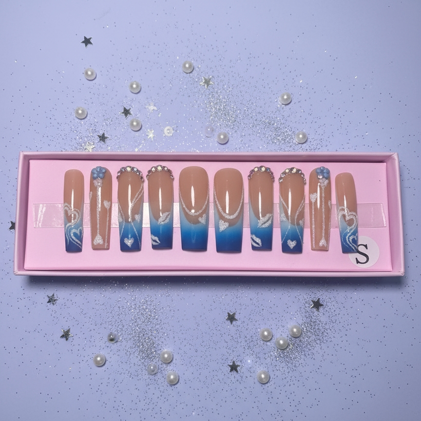 Set of gradient nail art designs in a pink box on a light purple background with decorative elements.